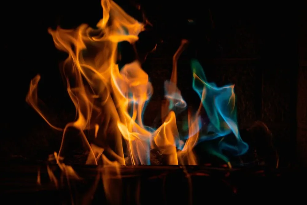 Close-up of a flame burning against a dark background, a fire sign image