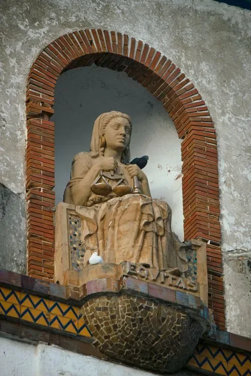 A weathered stone statue of a seated figure