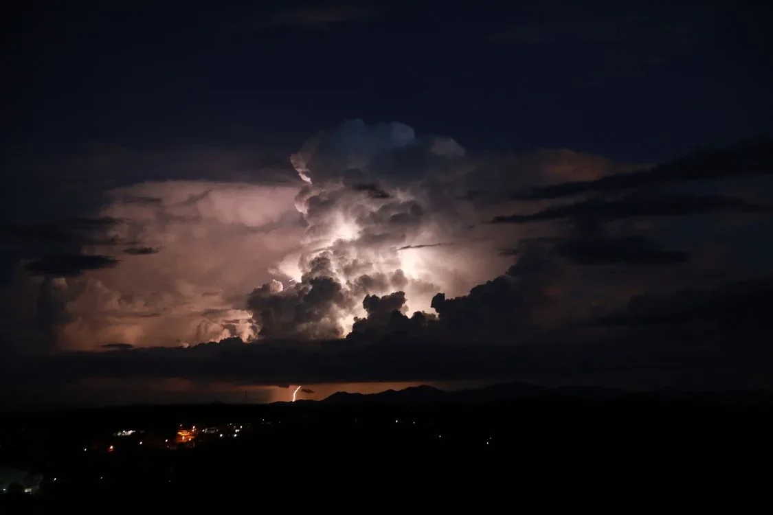 Dark storm clouds and lightning over a quiet town