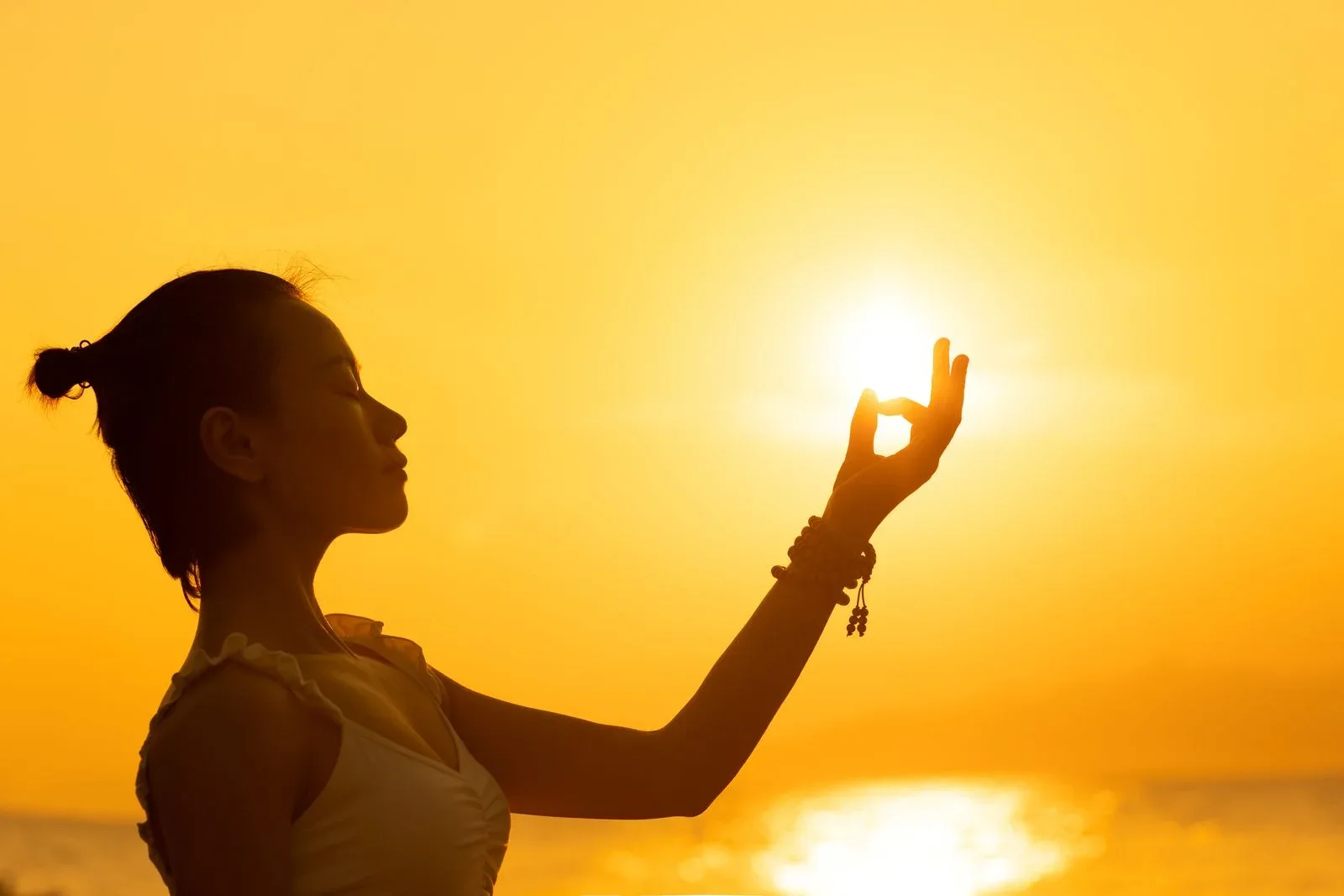 A silhouette in golden sunlight, an illustration of warmth rather than a photographed aura