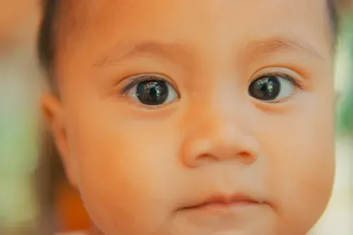 A baby's face resting calmly in soft light