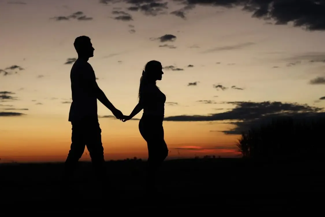 A couple holding hands at sunset