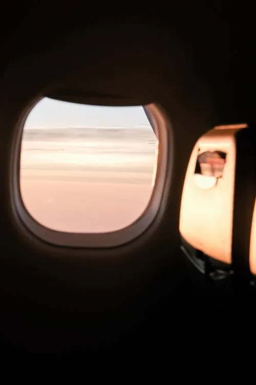A calm sky seen from an airplane window at sunrise