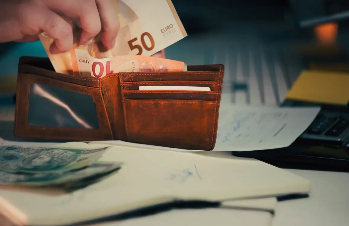 A wallet with a banknote being pulled from it