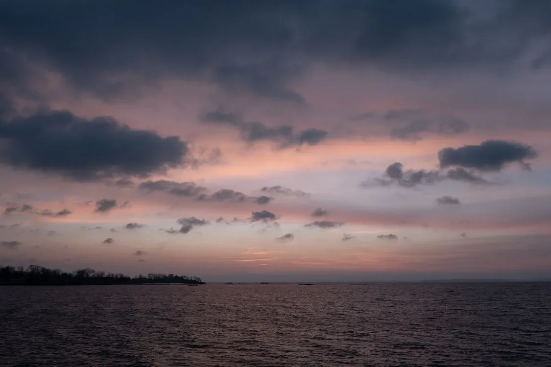 Soft pink sunrise light over a calm ocean