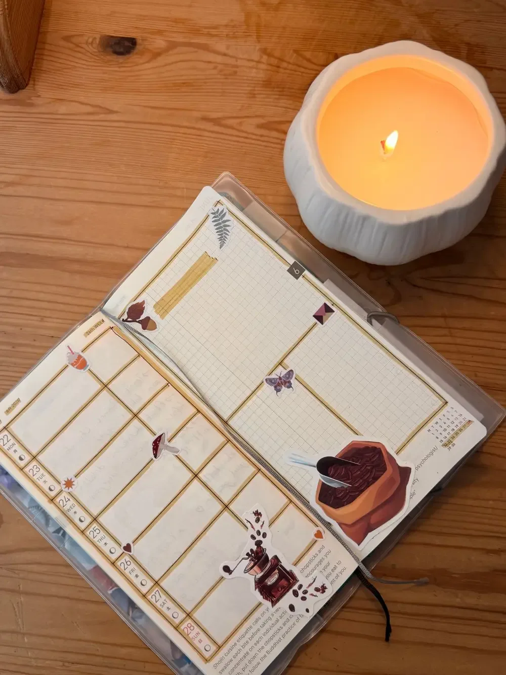 Open journal beside a lit candle on a wooden desk