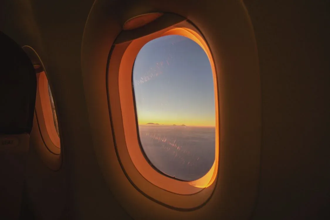 An airplane window framing clouds, a symbol of perspective