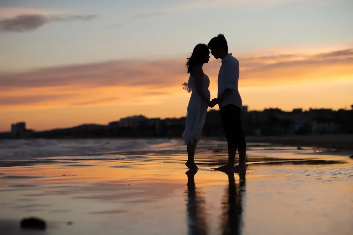 A couple on a beach at sunset