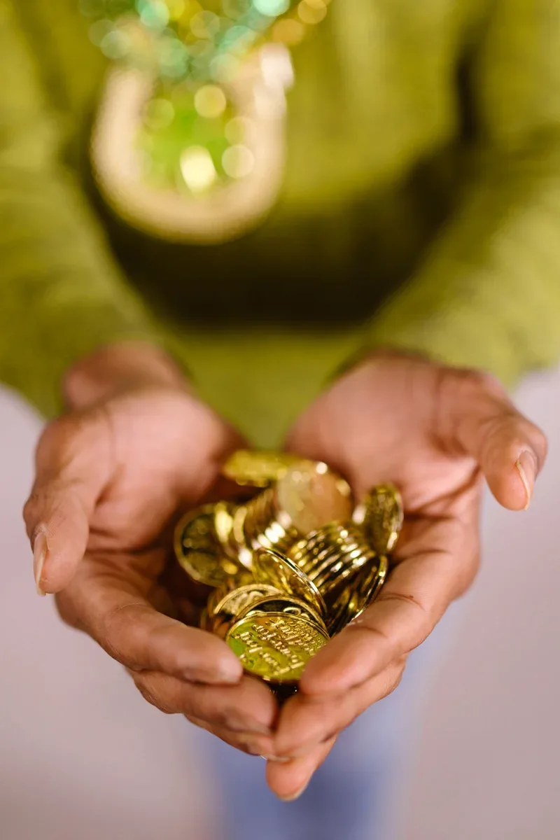 Hands holding gold-colored coins as an illustration of abundance