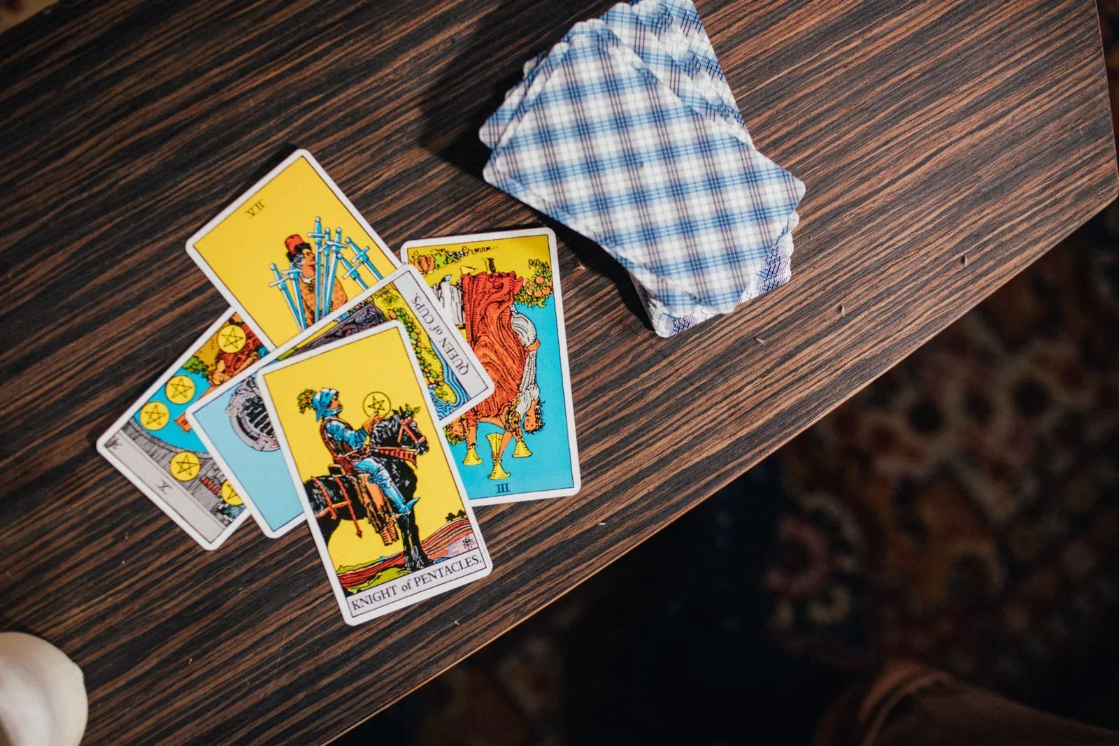 A close view of a tarot spread laid out on a wooden table