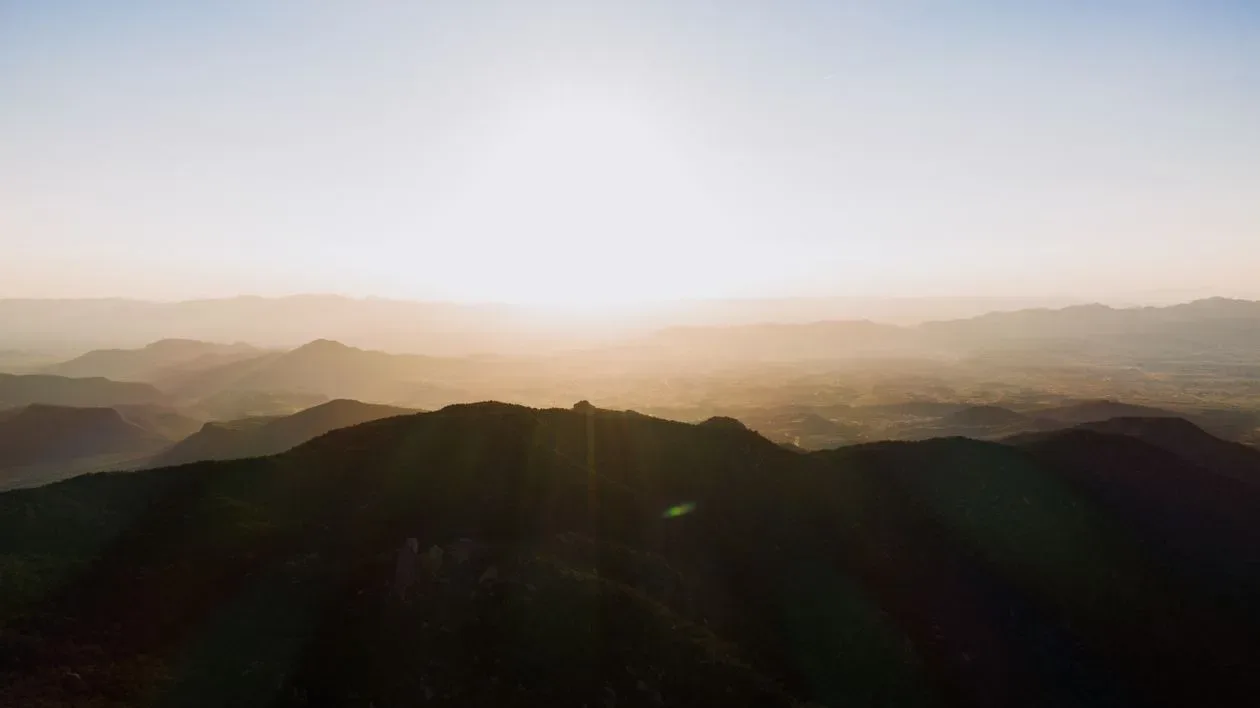 Sunrise breaking over a range of misty mountains