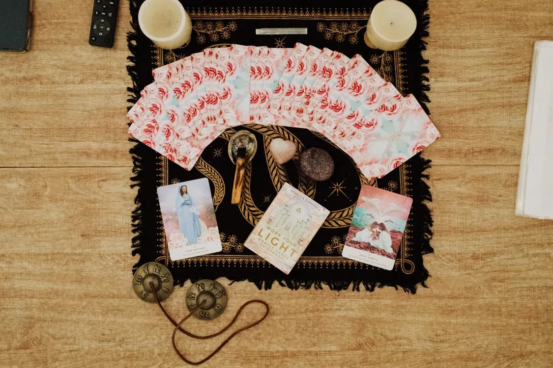 A tarot spread arranged with candles and reflective objects