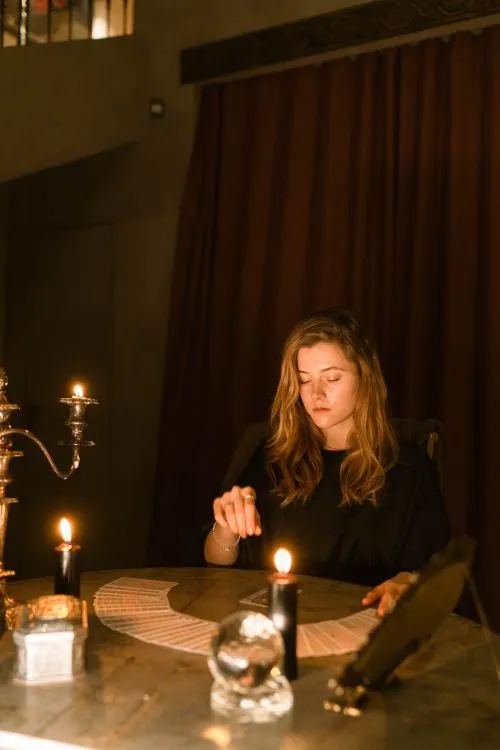 A tarot reader working with cards by candlelight