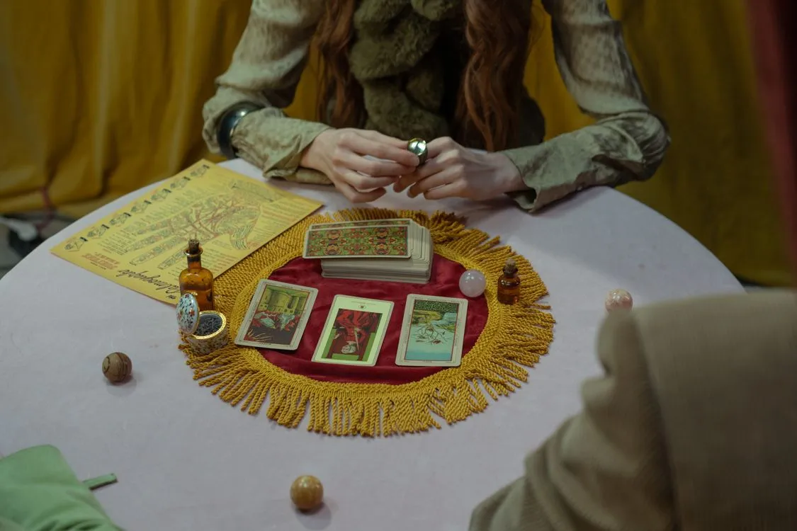 A tarot reader arranging cards on a table for a reflective session