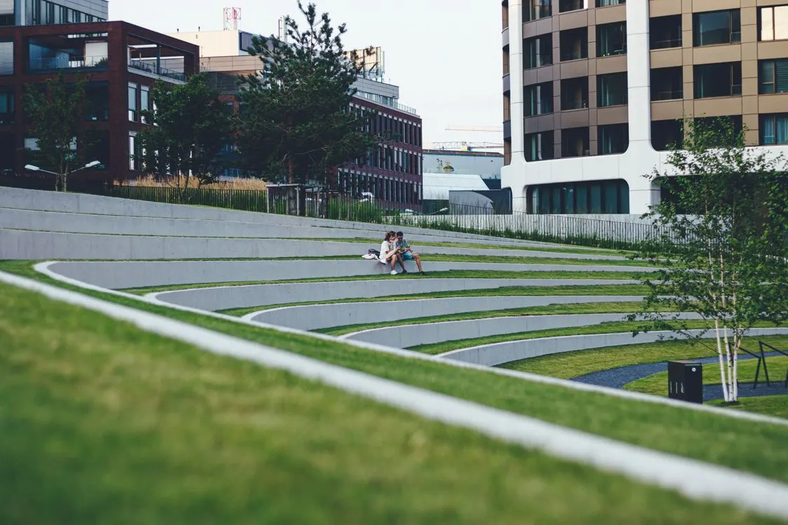 Two people spending time together on a grassy urban lawn