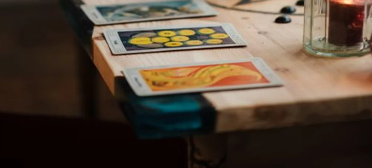 Tarot cards laid on a table beside lit candles