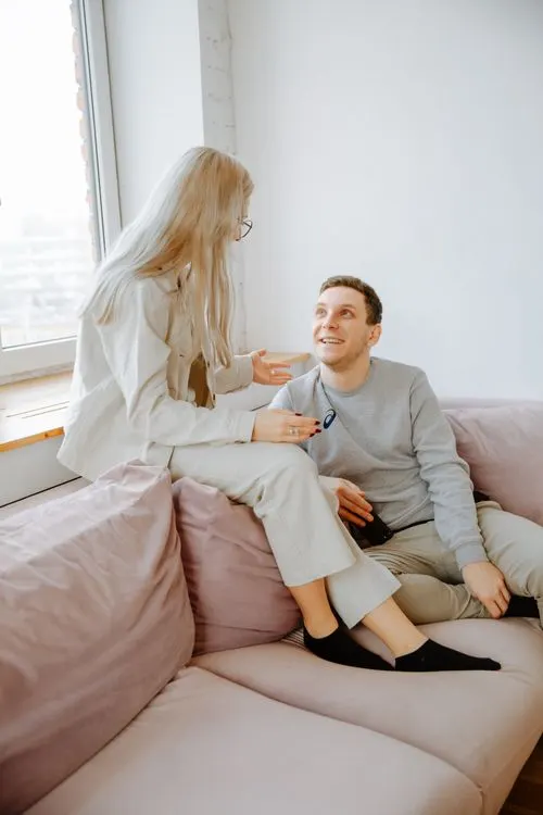 Two people having a conversation while sitting together indoors